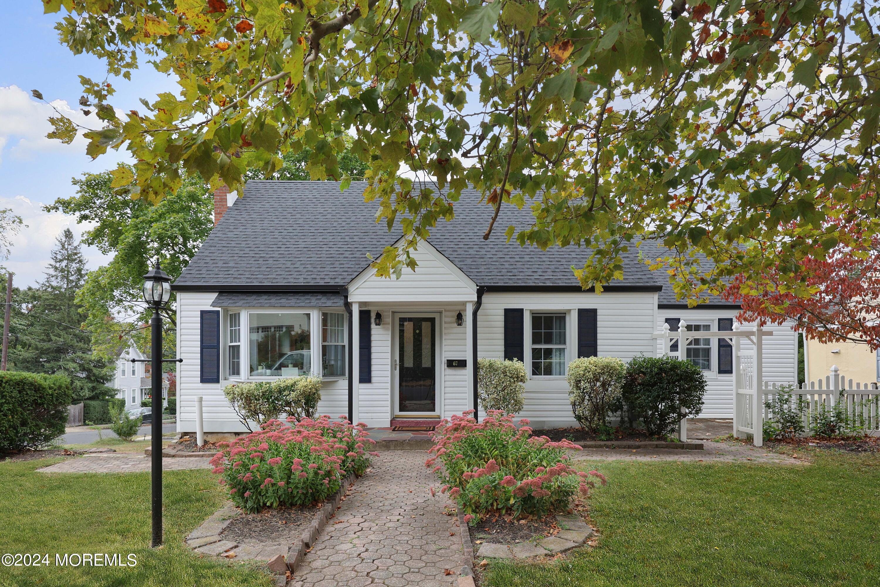 a front view of a house with a yard and potted plants