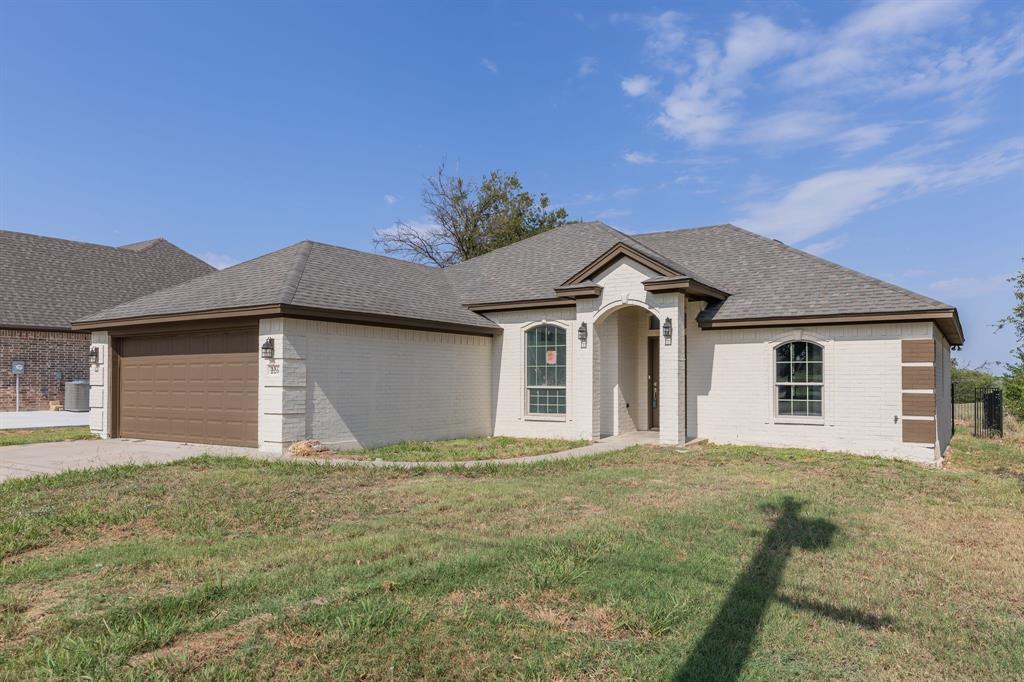 a front view of a house with yard and garage