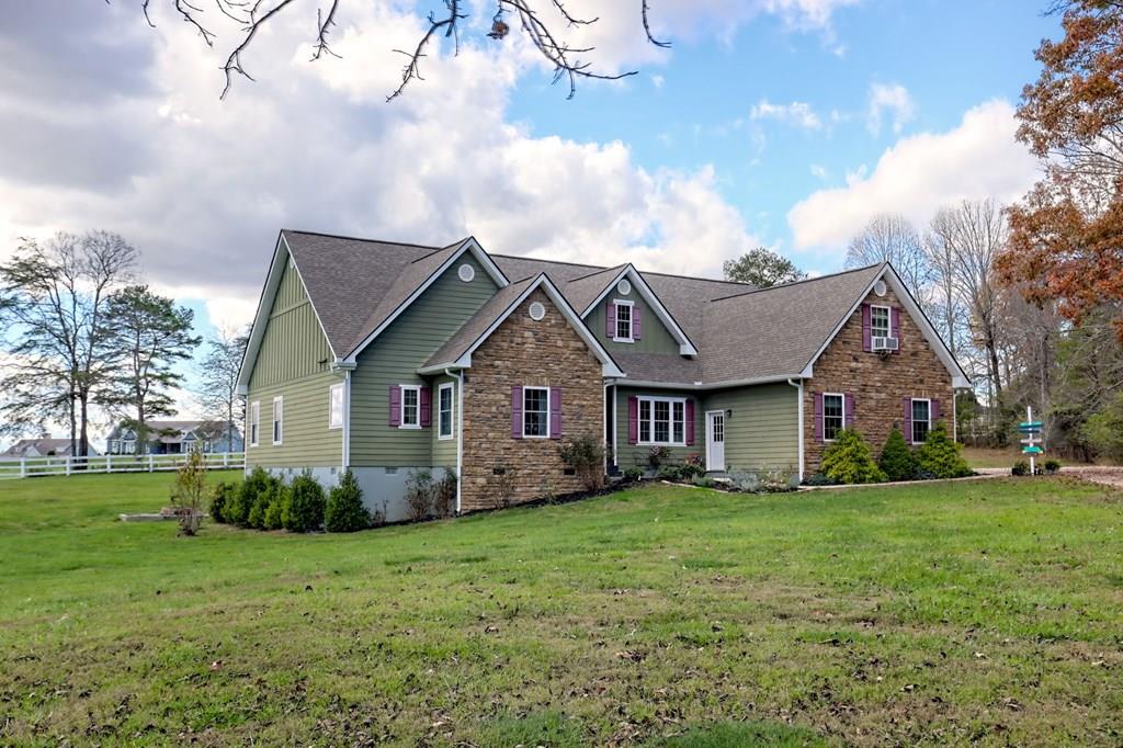 a view of a house next to a yard with big trees