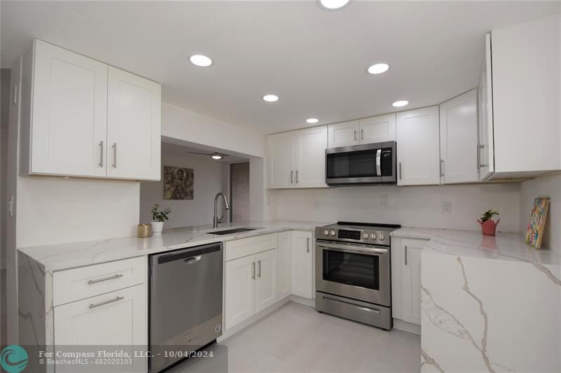 a kitchen with white cabinets stainless steel appliances and sink