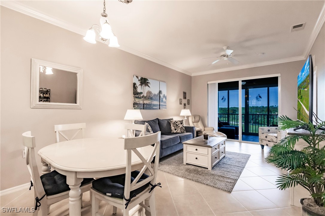 a living room with furniture a chandelier and a dining table