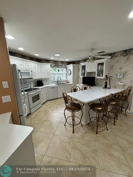 a kitchen with a sink and chairs