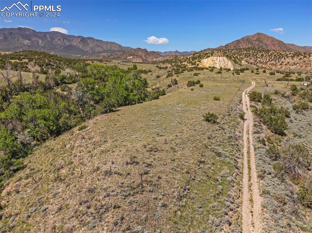 Aerial view of property which is to the left of the dirt road, from approximately the foreground of this photo to the end of the visible dirt road in this photo.  There are no structures on this property.