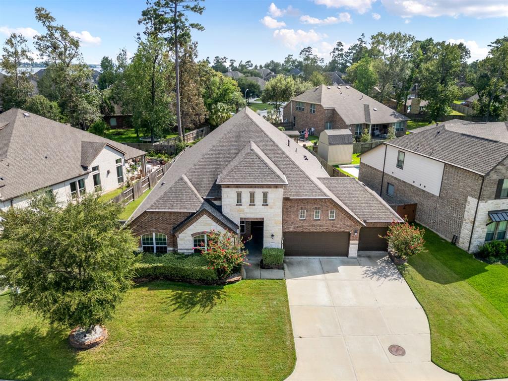 a aerial view of a house next to a yard with plants and large trees