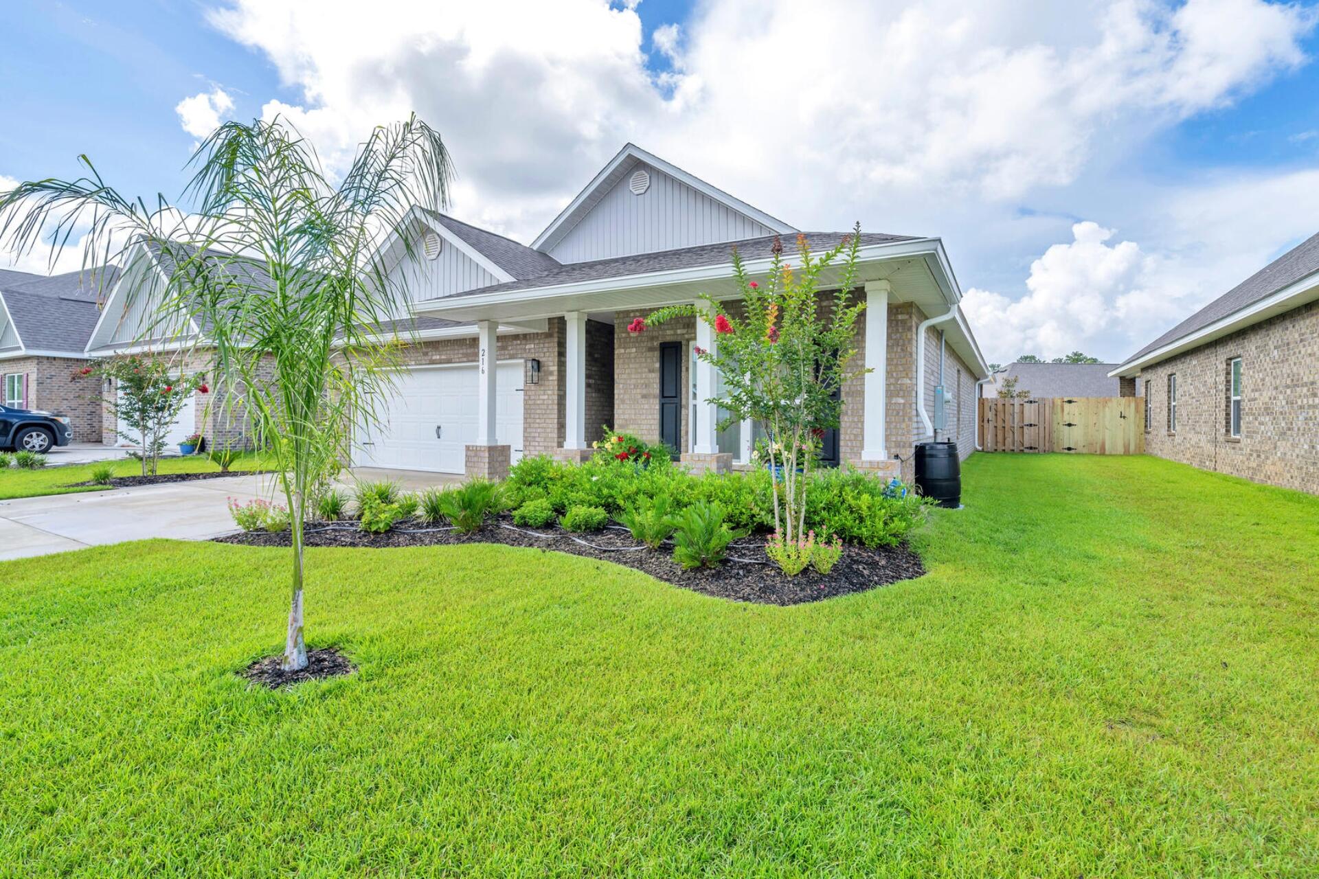 a front view of a house with a garden and plants