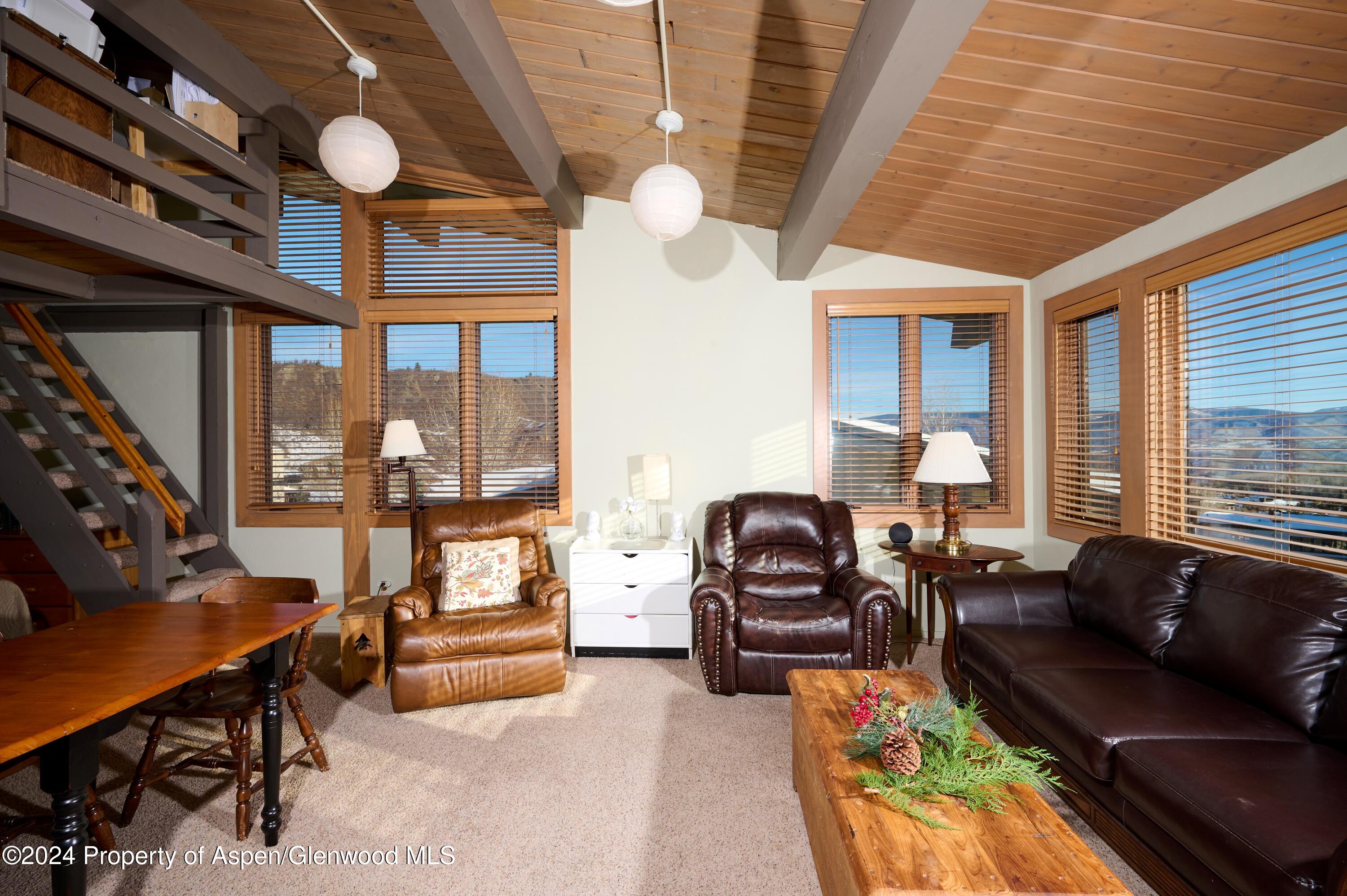 a living room with furniture fireplace and a large window