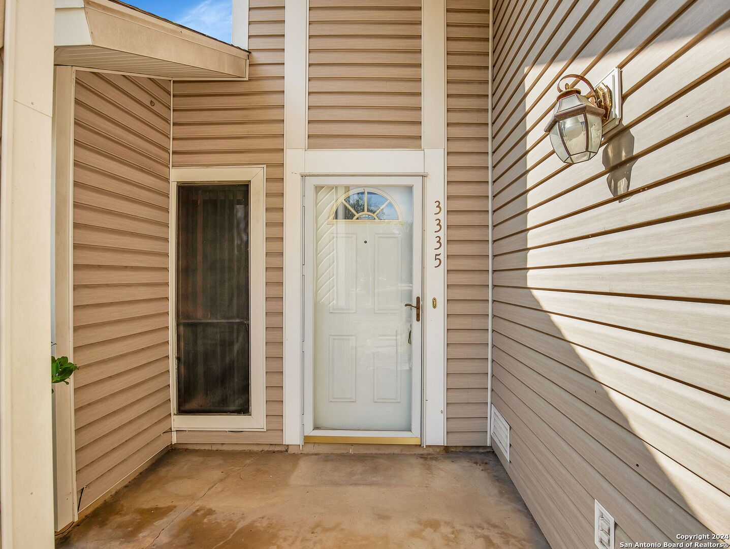 a view of a porch with a door and wooden floor