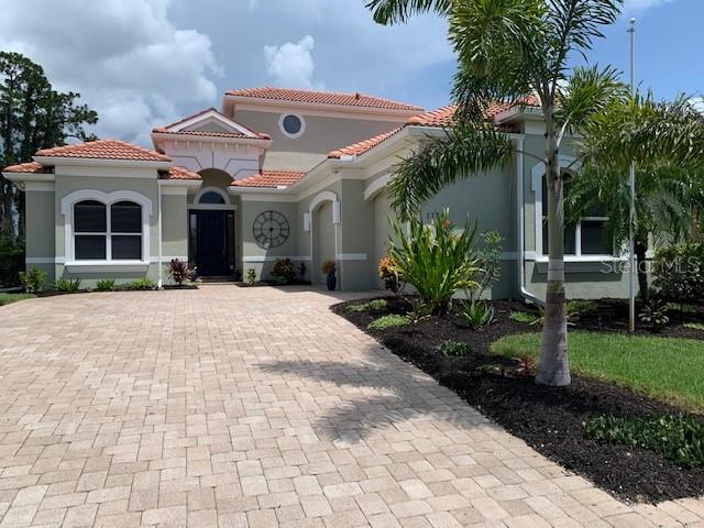 a front view of a house with a yard and potted plants