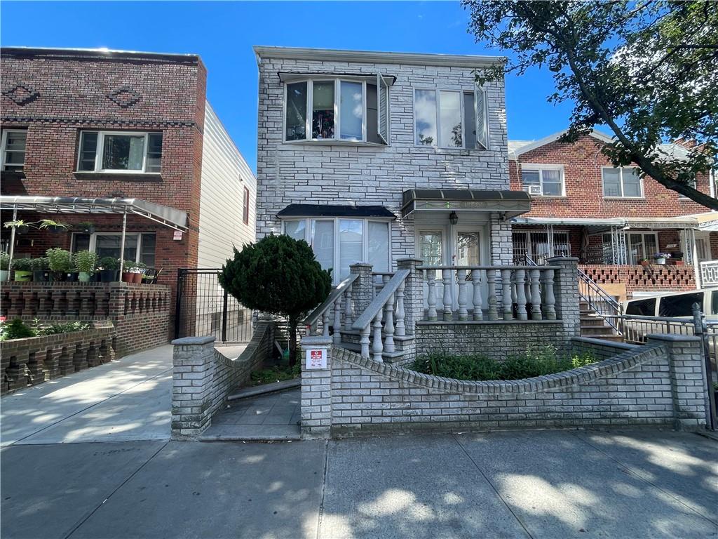 a view of a brick house with many windows next to a road