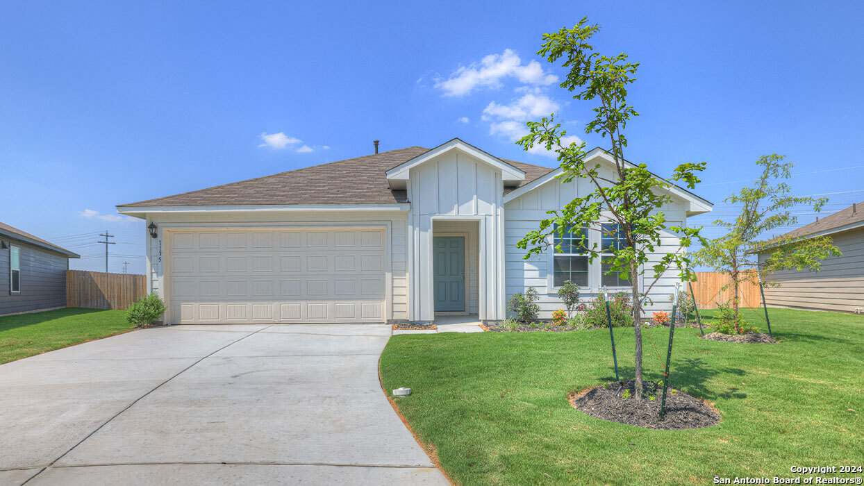 a front view of a house with a garden and plants