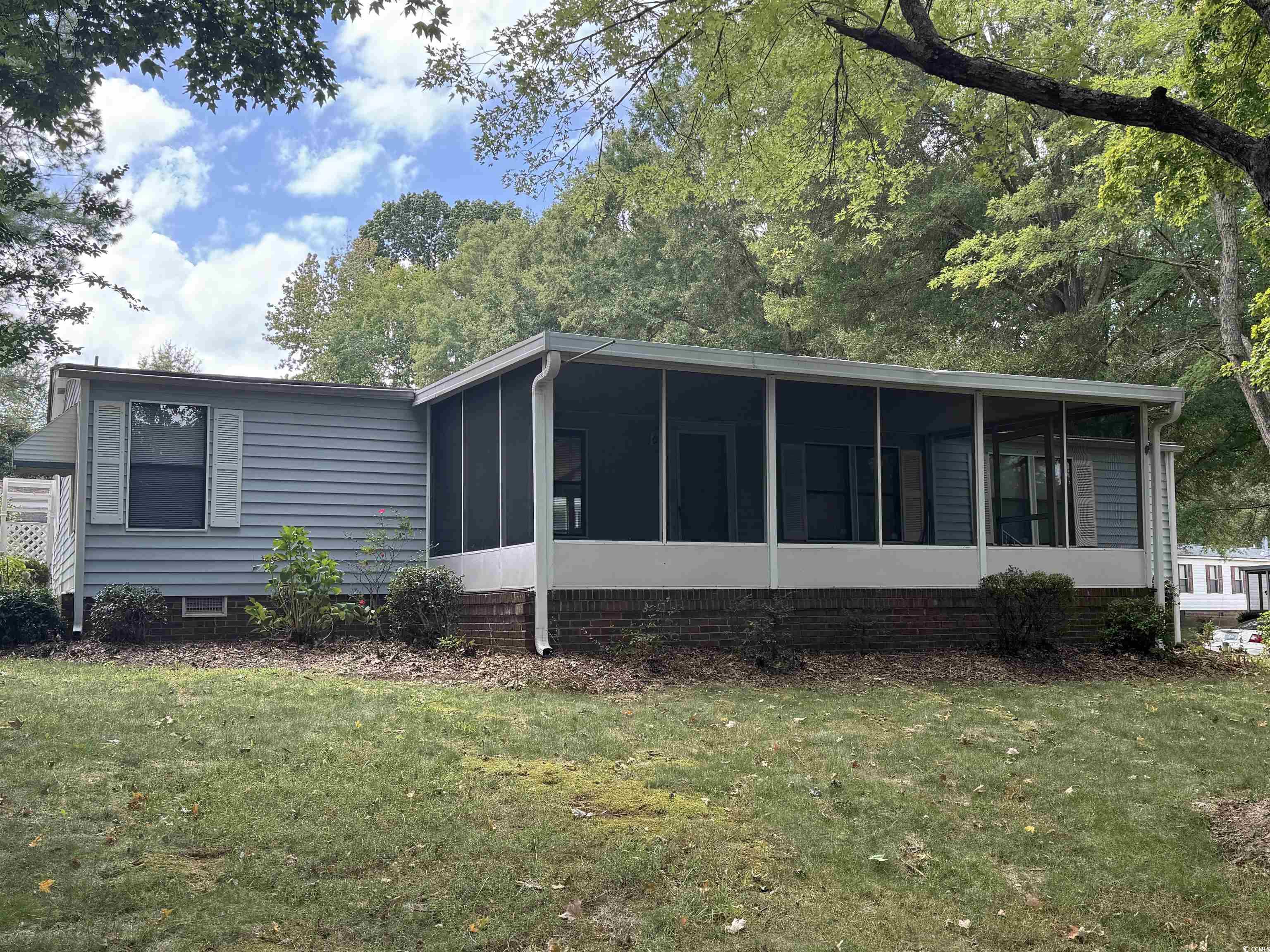 Back of house featuring a yard and a sunroom