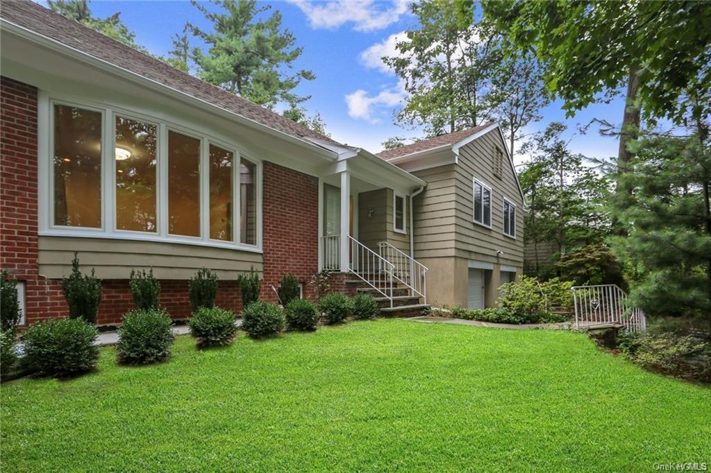 a front view of a house with a garden and plants