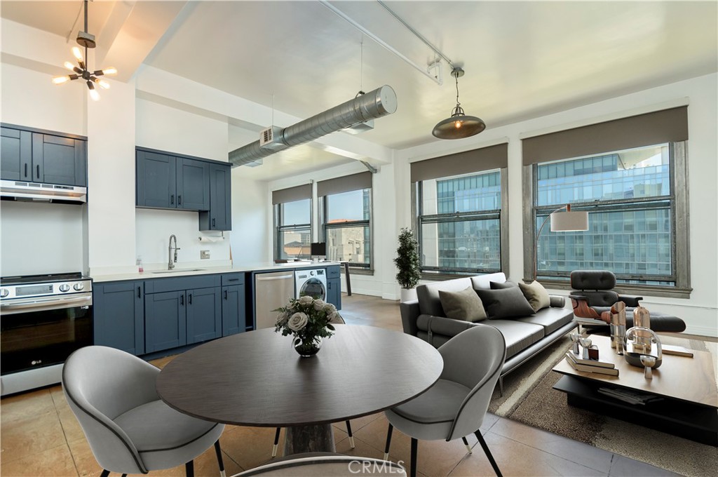 a living room with couches a dining table and chairs with wooden floor