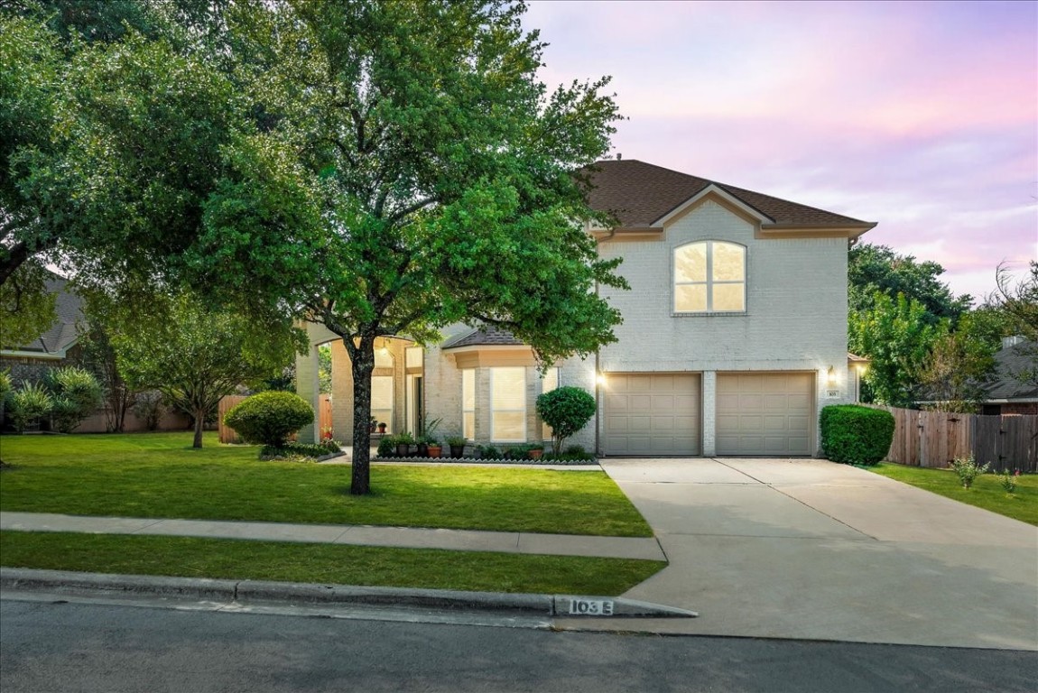 a front view of a house with a yard and garage