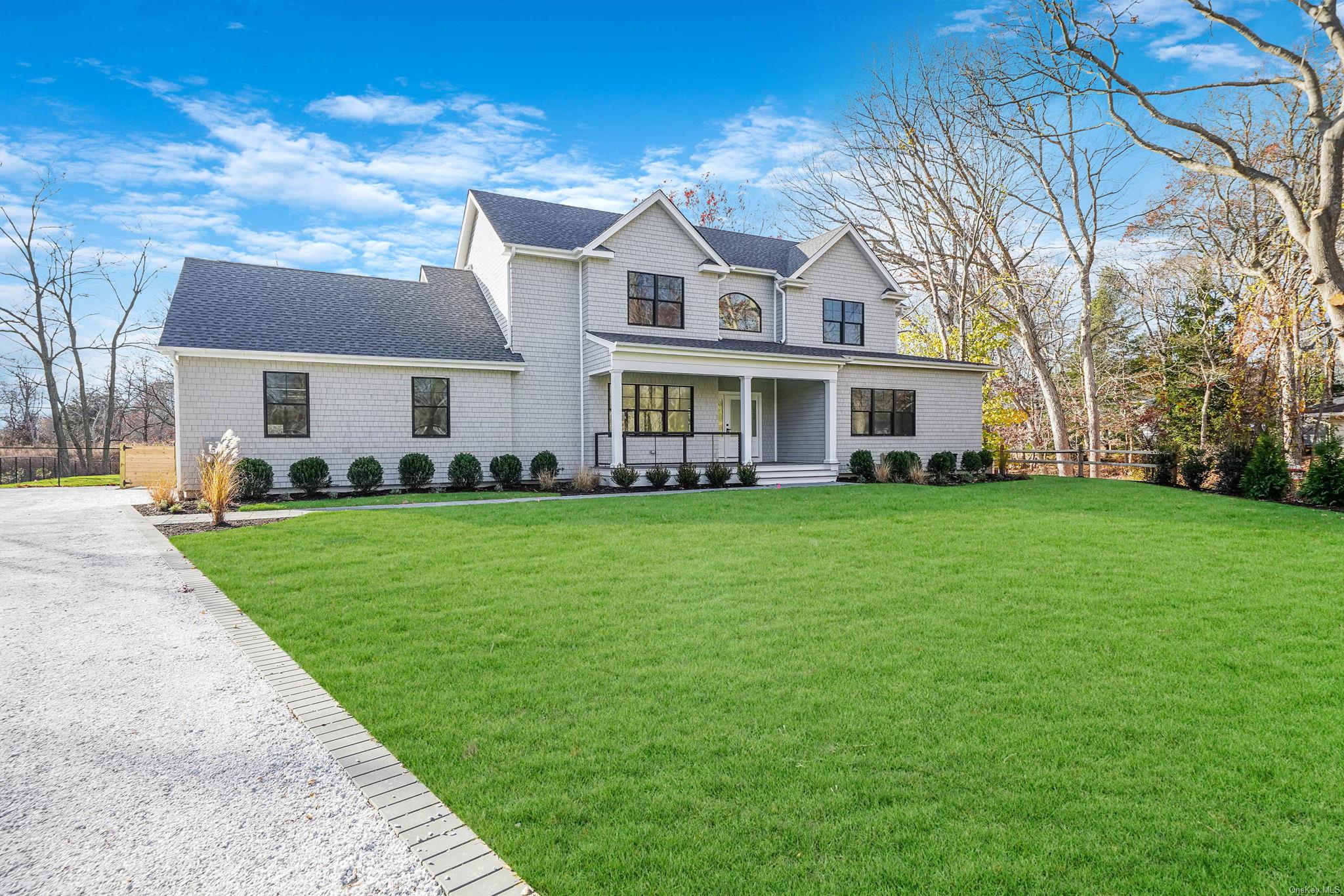 a front view of a house with a garden and trees