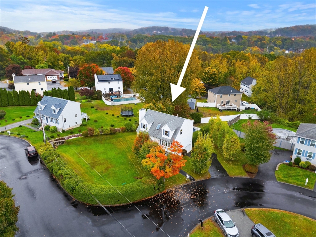 an aerial view of a swimming pool with a yard and mountain view