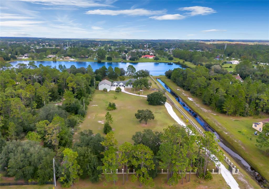 Everything you could want (and more - LAKEFRONT with a DOCK!) on 6 ACRES, fenced/cross fenced and gated with a beautiful 4-bedroom, 2-bath **POOL HOME** + an additional DETACHED GARAGE with a 2-bed, 1-bath apartment featuring a full kitchen and 1500 sq ft of living space!