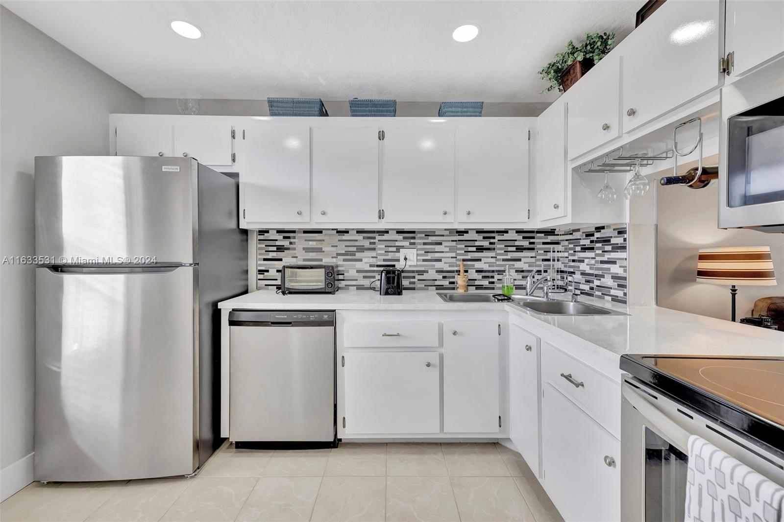 a kitchen with stainless steel appliances a refrigerator sink and cabinets