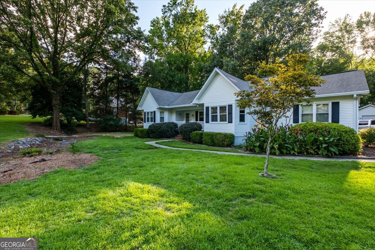 a front view of a house with a yard and trees