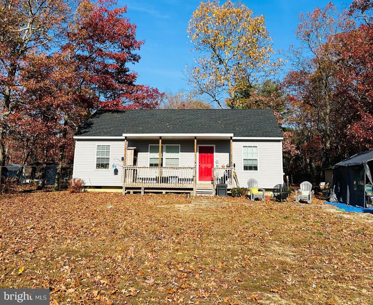 a front view of house with yard and trees in the background