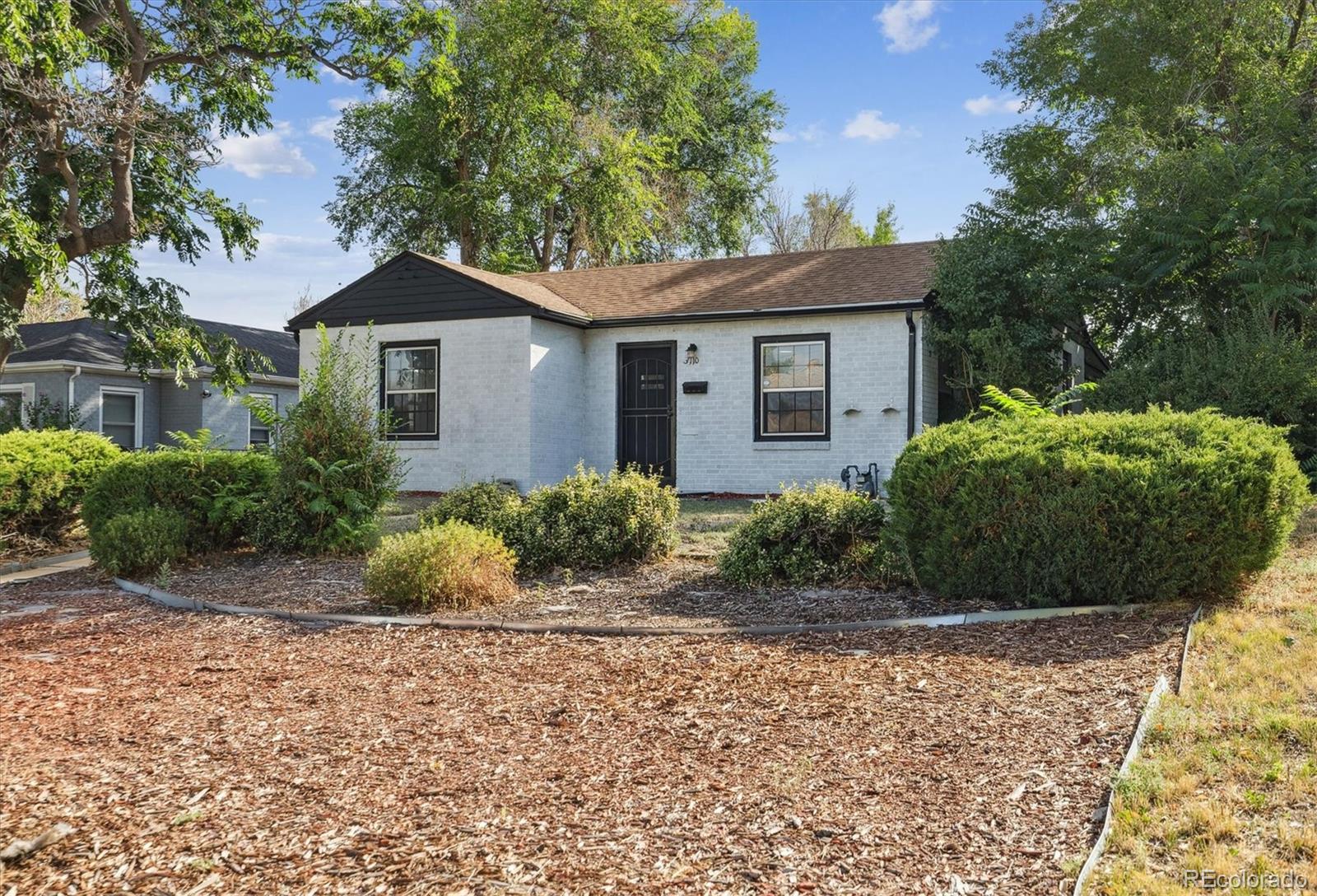 a front view of a house with a yard and trees