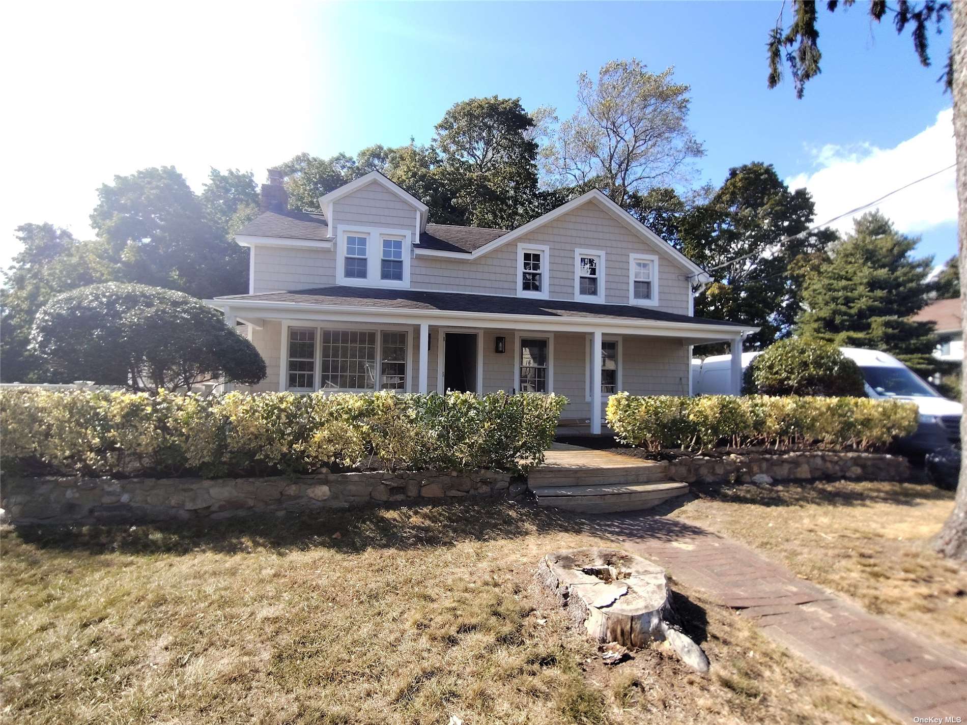 a front view of a house with a yard and potted plants