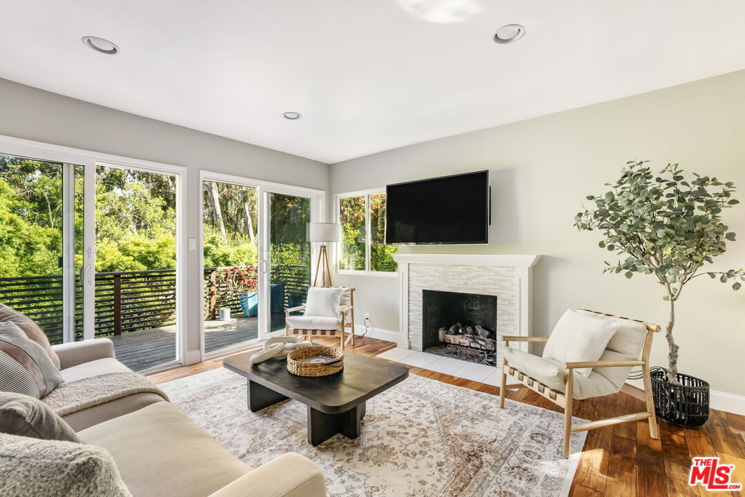 a living room with furniture a fireplace and a flat screen tv