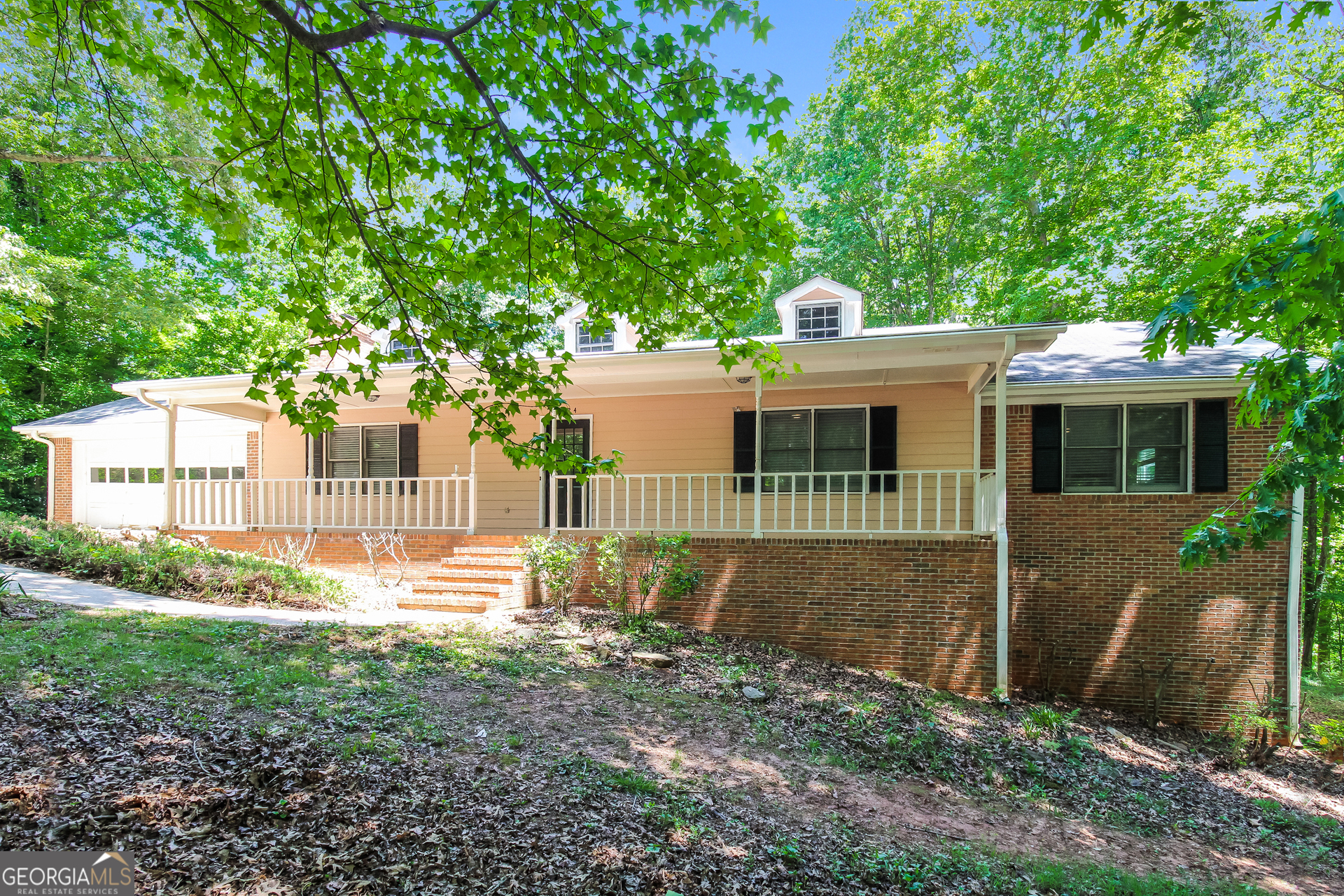 a view of a house with a yard and a large tree