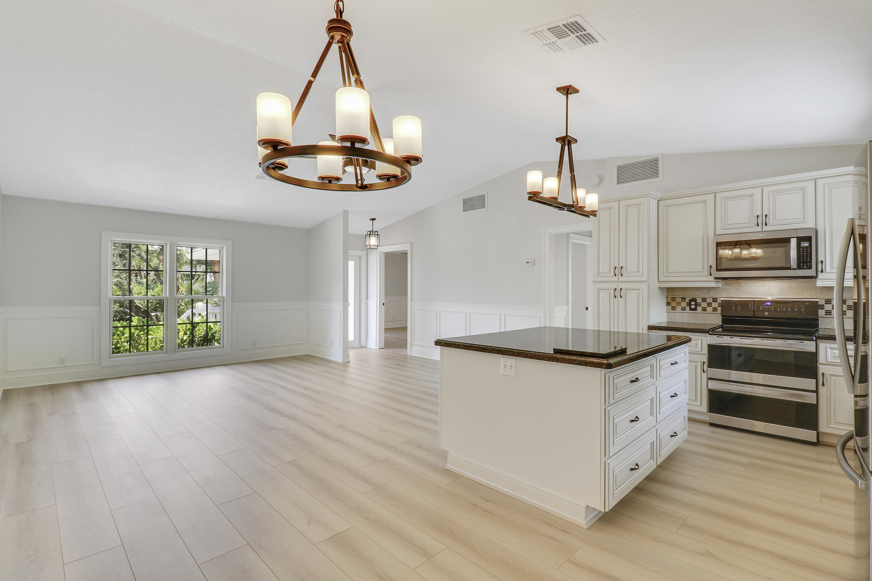 a kitchen with stainless steel appliances granite countertop a stove and a wooden floors