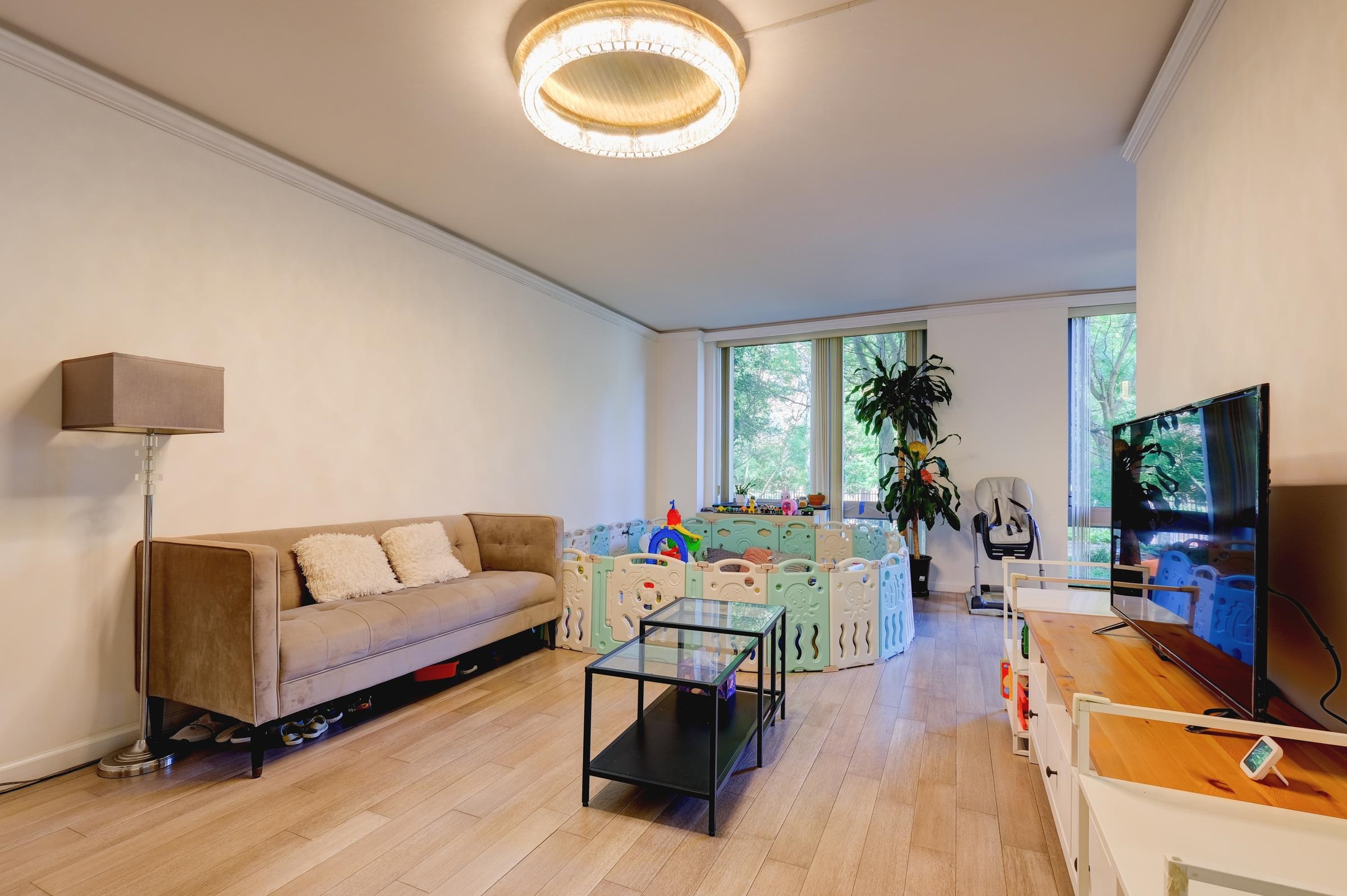 a living room with furniture a flat screen tv and a large window