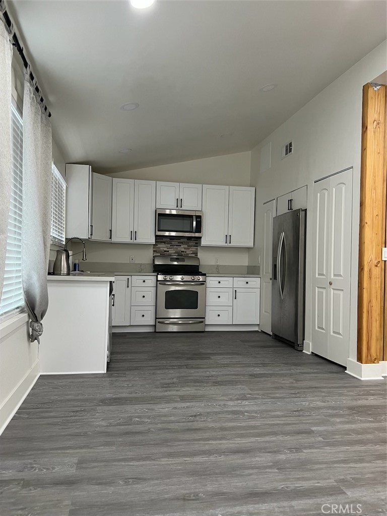 a kitchen with stainless steel appliances a refrigerator and a stove top oven