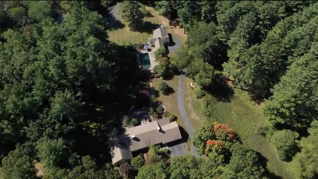 an aerial view of residential house with outdoor space and trees all around