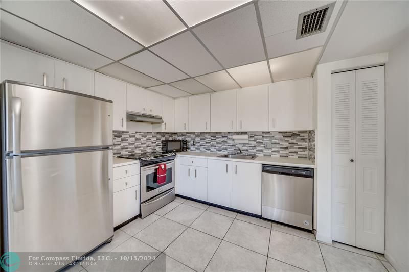 a kitchen with stainless steel appliances a refrigerator sink and cabinets