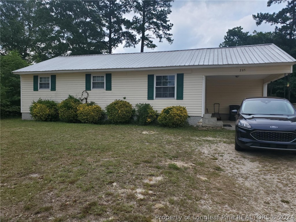 a view of a house with a backyard and bushes