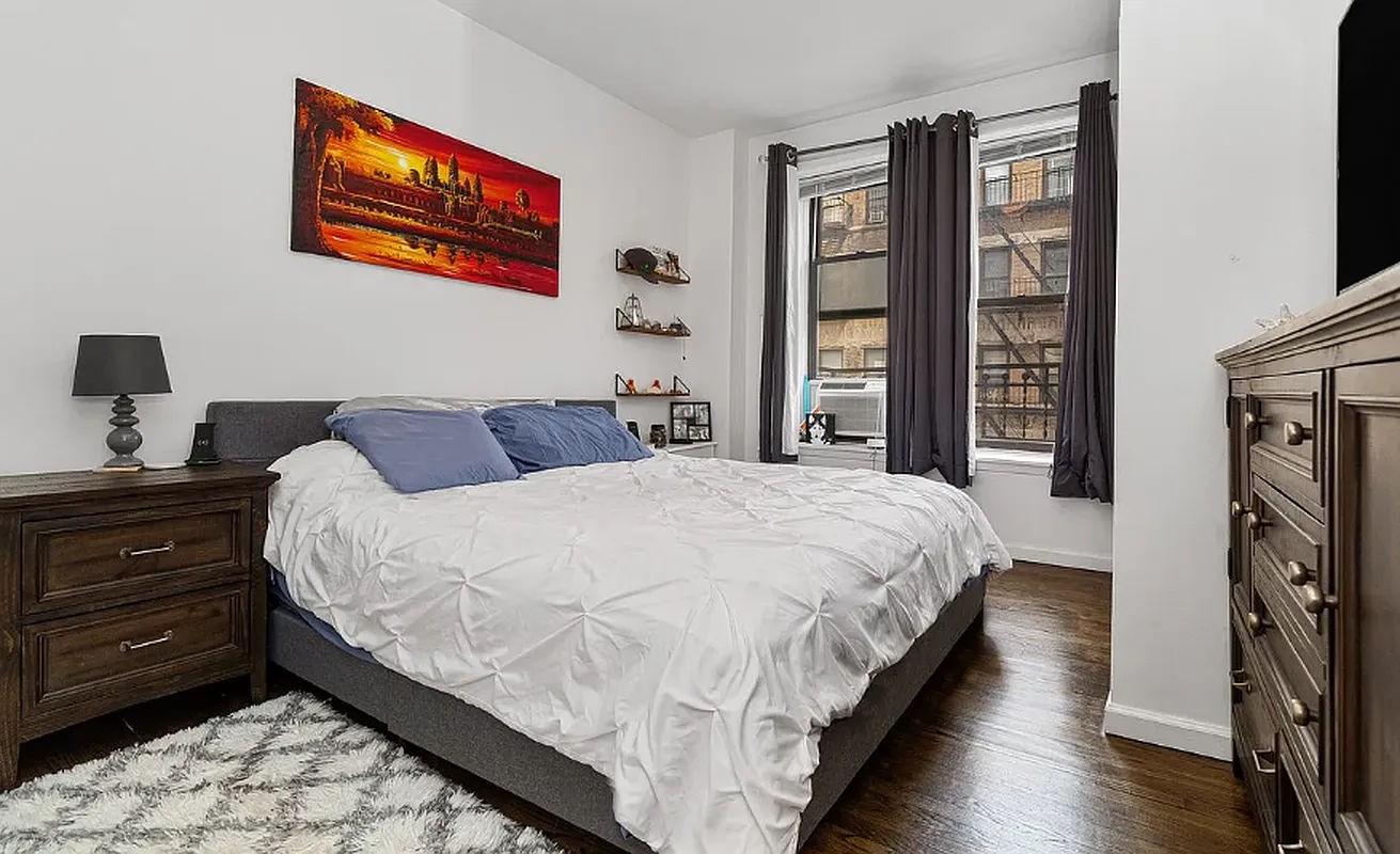 a bedroom with bed and wooden floor