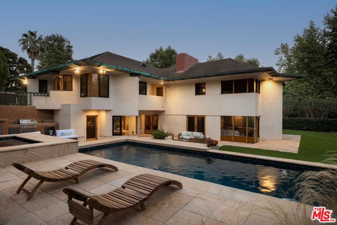 a view of a patio with couches table and chairs with wooden floor and fence