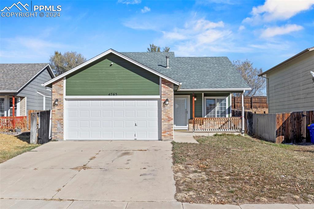 Ranch-style house featuring covered porch and a garage