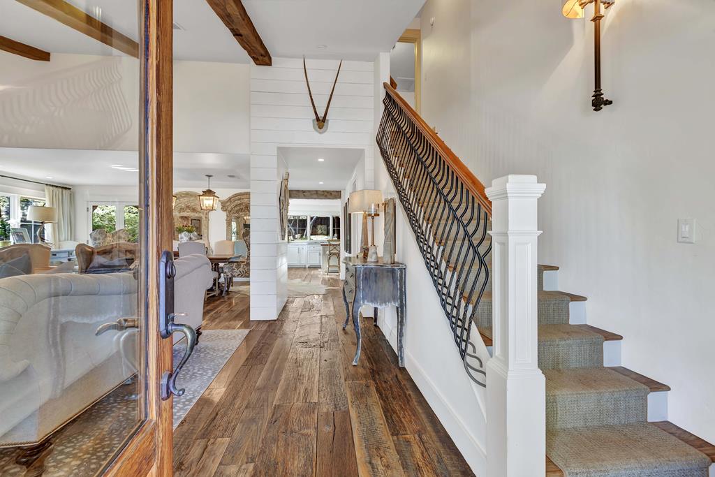 a view of a hallway with wooden floor and staircase