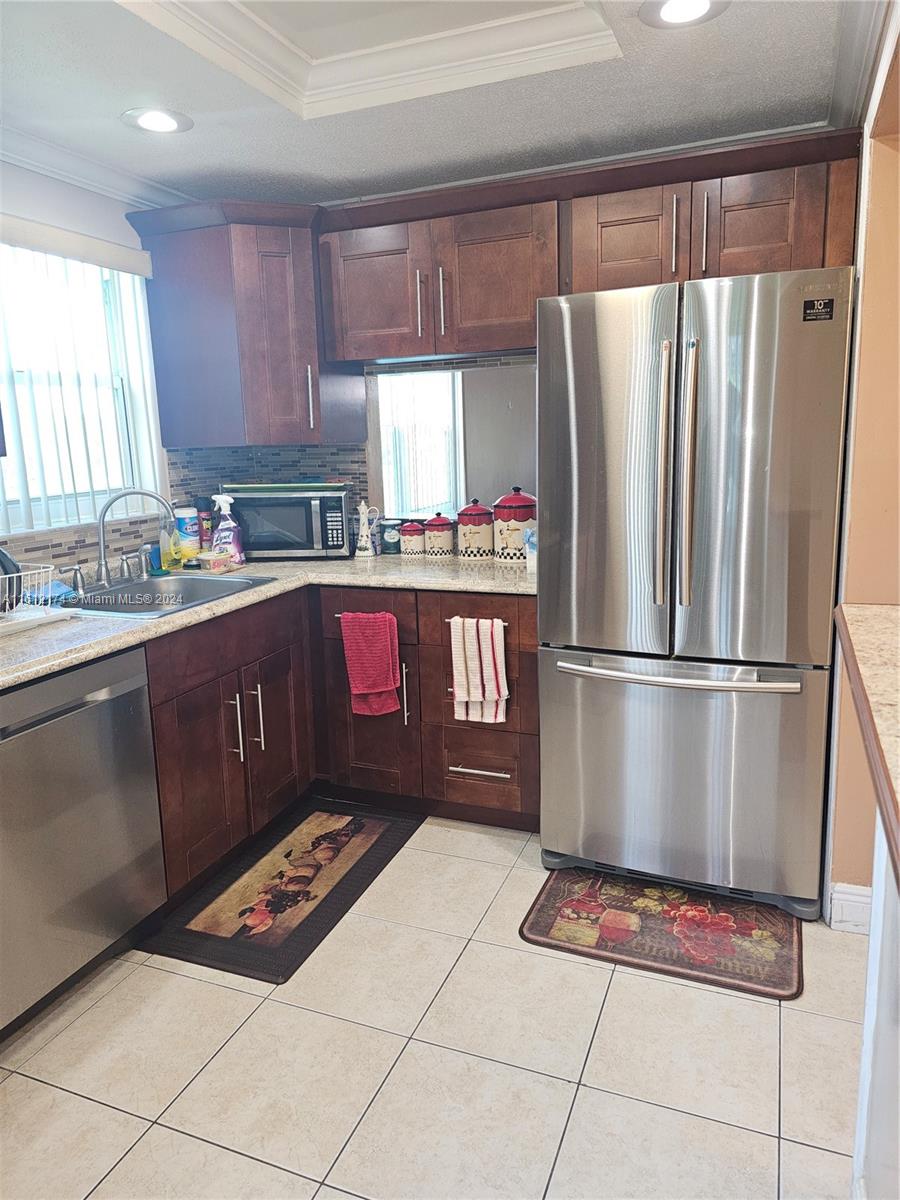 a kitchen with stainless steel appliances granite countertop a refrigerator sink and cabinets