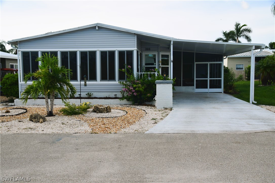 front view of house with potted plants and a large window