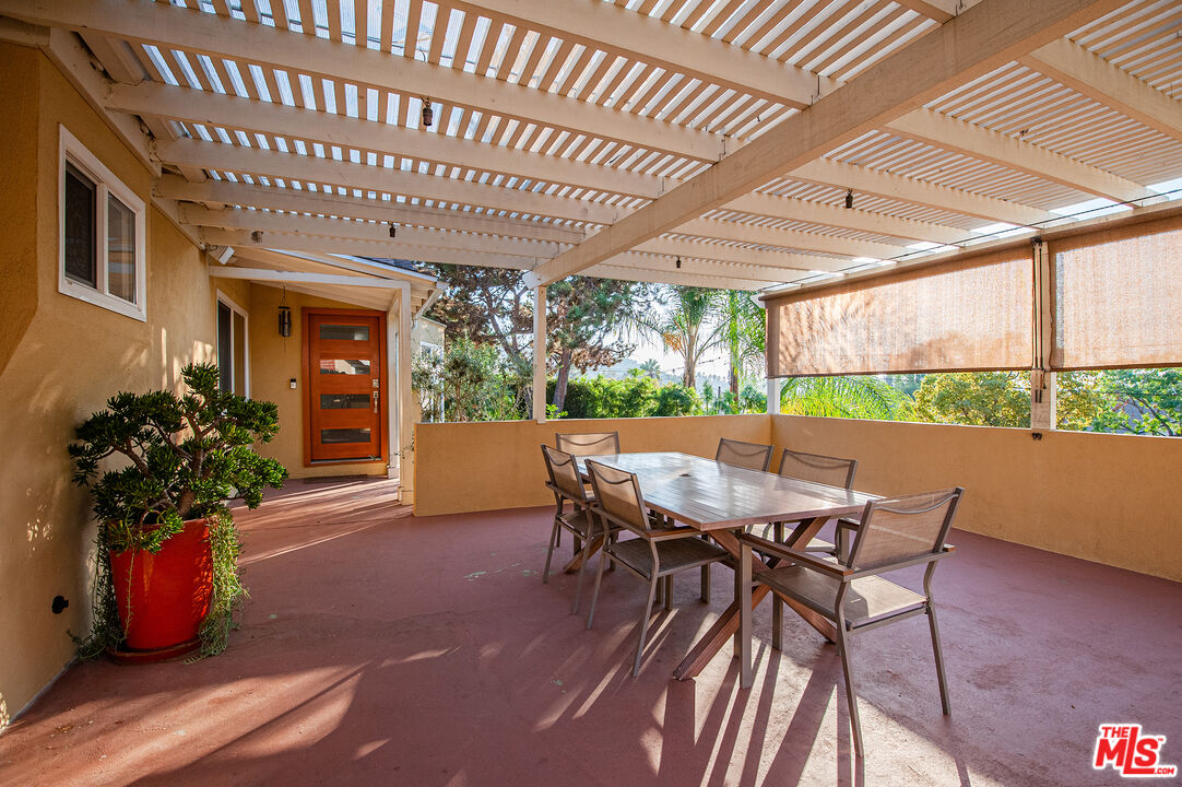 a view of a porch with furniture and a yard