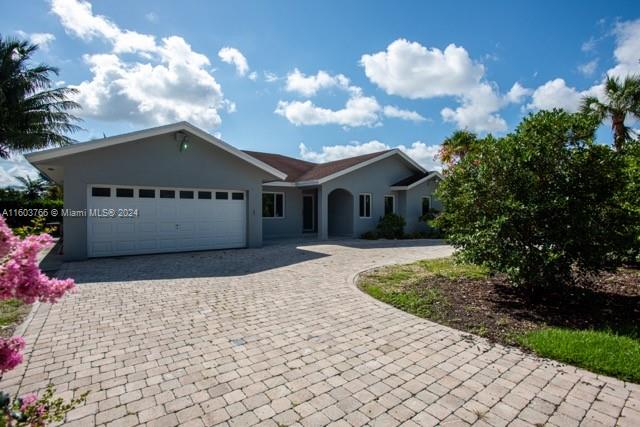 a front view of a house with a yard and a garage