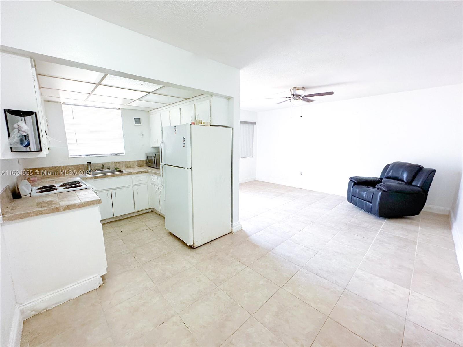 a kitchen with a refrigerator and white cabinets