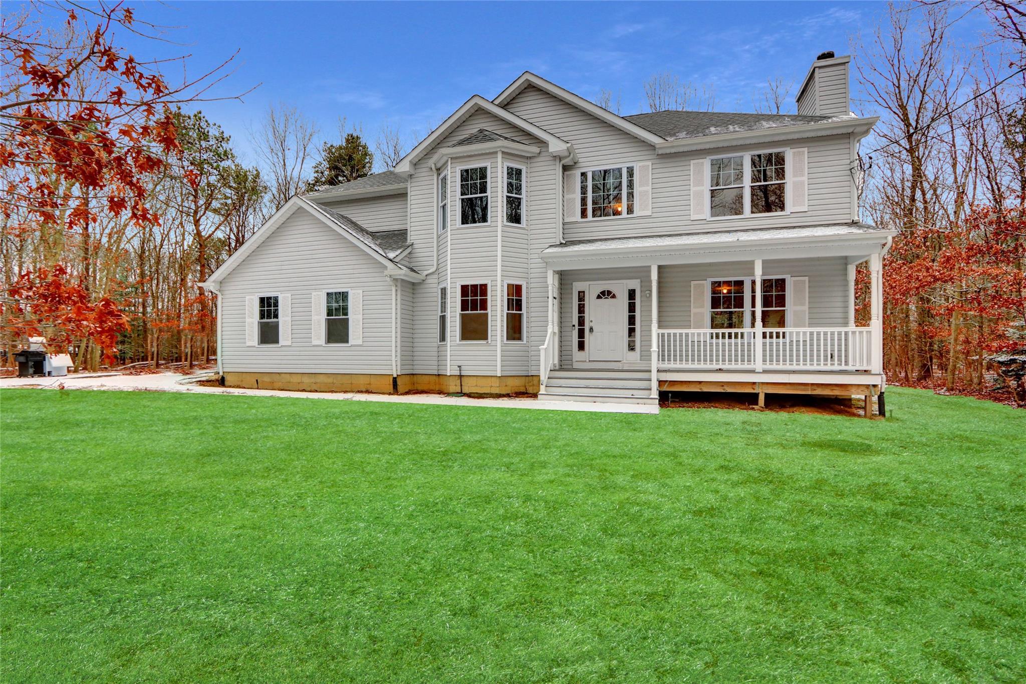 View of front facade with covered porch and a front lawn