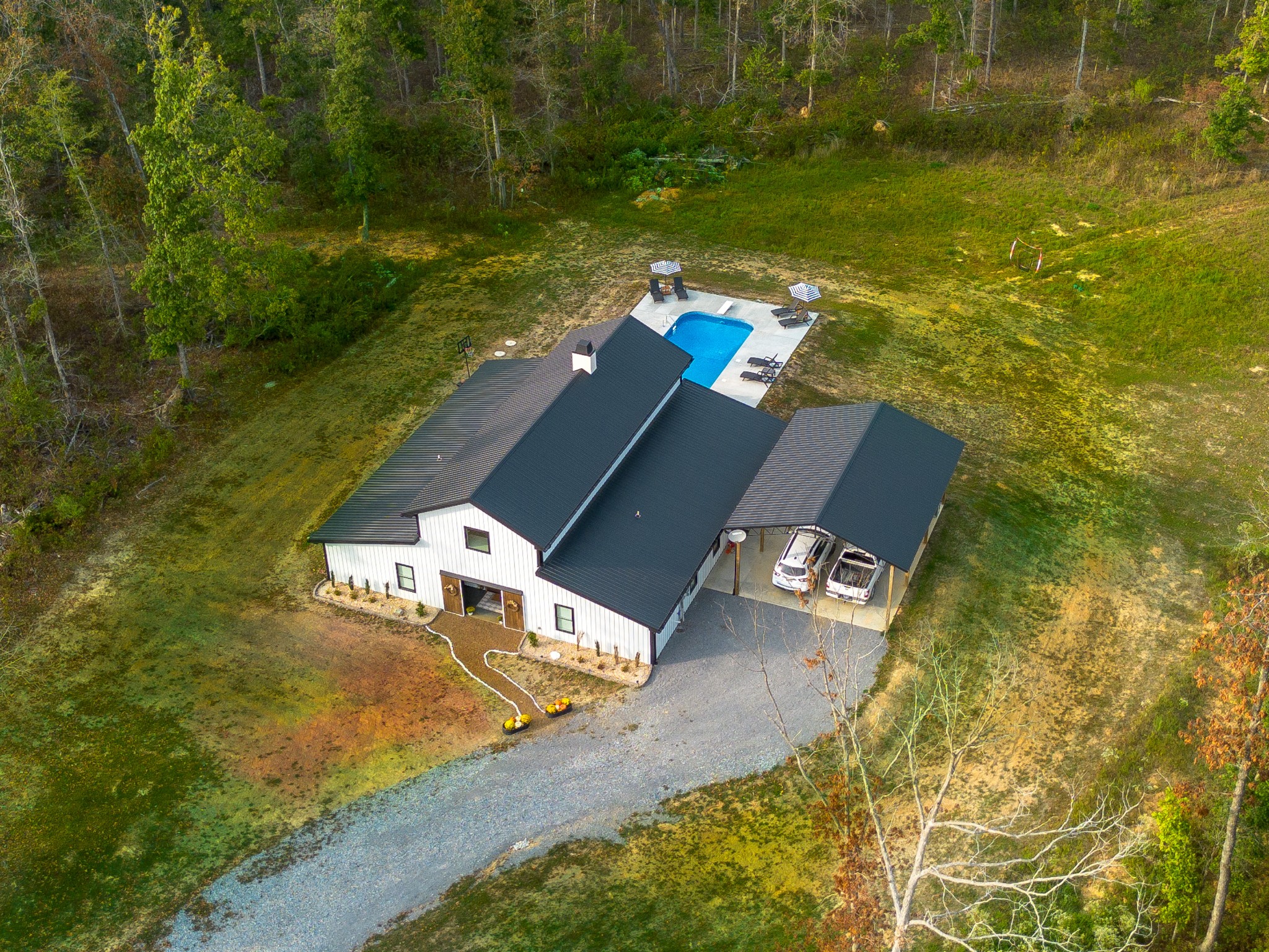 an aerial view of a house with a yard lake and trees