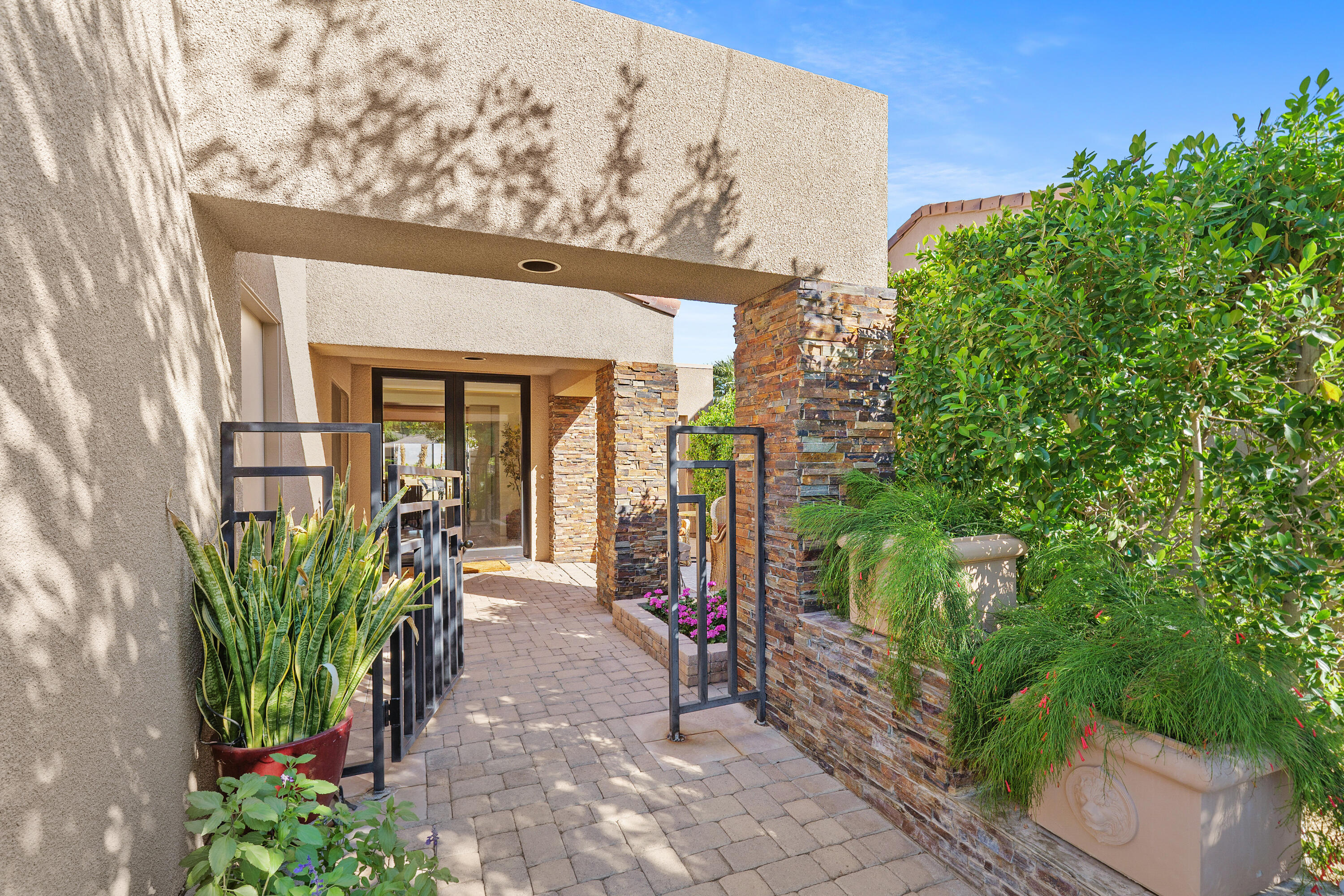 a front view of a house with a bunch of plants