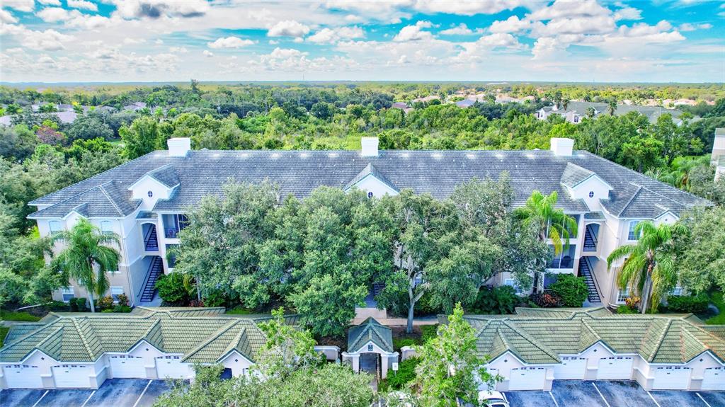 an aerial view of a house with a garden and trees all around