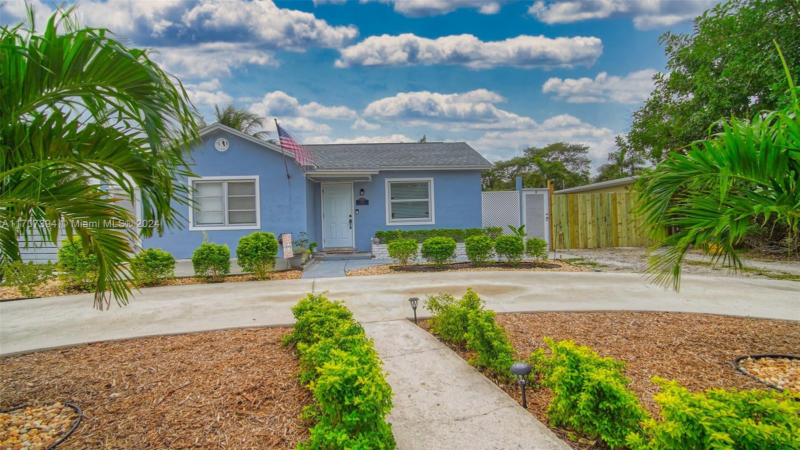 a front view of a house with a yard and potted plants