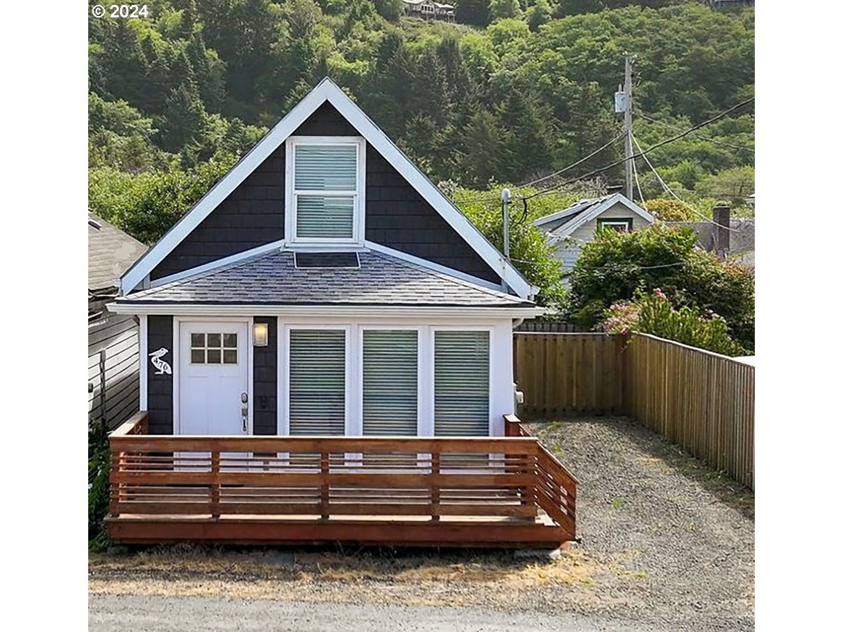 a view of a house with a small yard and wooden fence