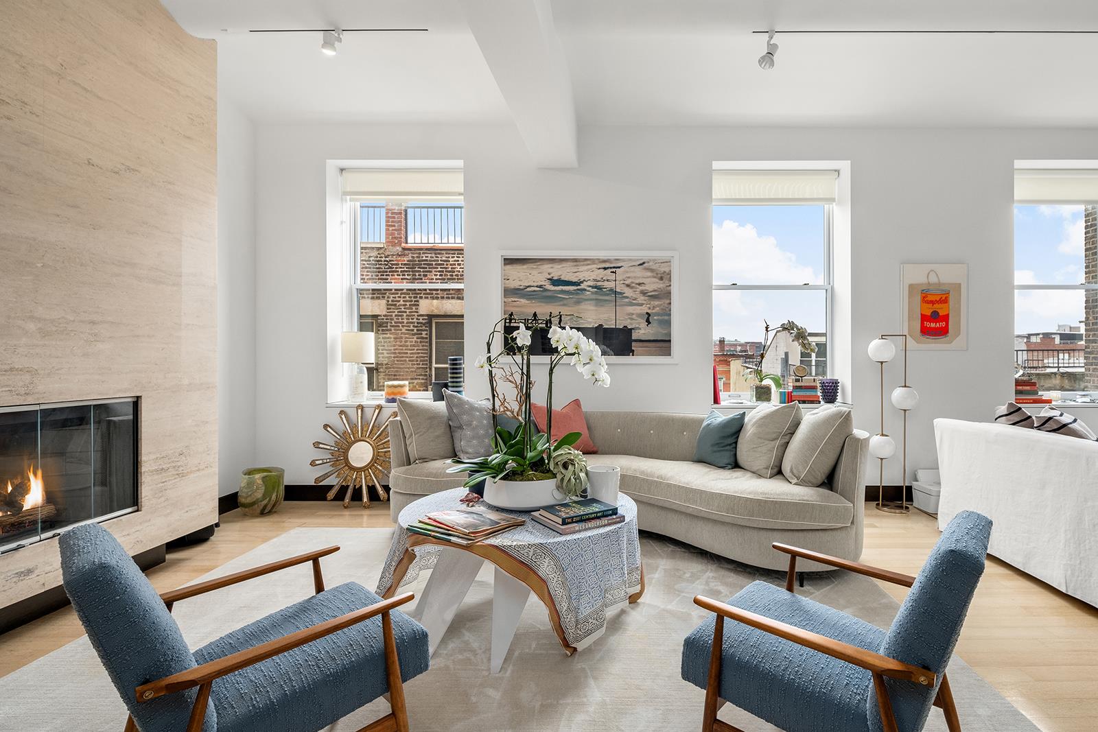 a living room with furniture fireplace and a large window